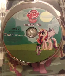 Size: 500x590 | Tagged: safe, derpibooru import, princess cadance, spike, alicorn, dragon, pony, dvd, female, fim logo, mare, my little pony logo, oops, photo, smiling, sparkles, spread wings, wings, you had one job