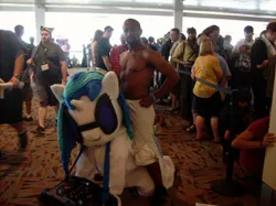 Size: 1280x959 | Tagged: safe, derpibooru import, vinyl scratch, human, pony, unicorn, convention, cosplay, crowd, duo focus, female, fursuit, glasses, indoors, irl, isaiah mustafa, looking at you, male, man, mare, meme, old spice, old spice guy, photo, pose, queue, riding, topless, towel