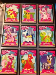 Size: 1936x2592 | Tagged: safe, derpibooru import, apple bloom, big macintosh, cheerilee, granny smith, princess cadance, scootaloo, shining armor, sweetie belle, zecora, pony, zebra, card, irl, merchandise, photo, trading card