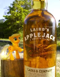 Size: 476x610 | Tagged: safe, artist:texasuberalles, derpibooru import, applejack, earth pony, pony, alcohol, applejack (drink), bottle, brushable, female, freckles, hatless, irl, laird & company, laird's applejack, looking up, mare, missing accessory, namesake, photo, pun, raised hoof, raised leg, smiling, solo, toy