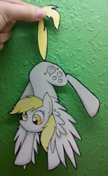 Size: 701x1140 | Tagged: dead source, safe, artist:winter-hooves, derpibooru import, derpy hooves, pegasus, pony, cute, female, hand, hanging, mare, paper child, paper pony, papercraft, photo, solo, spread wings, tail, tail pull, traditional art