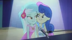 Size: 998x557 | Tagged: safe, derpibooru import, screencap, bon bon, lyra heartstrings, sweetie drops, equestria girls, rainbow rocks, bedroom eyes, eye contact, female, grin, just friends, lesbian, lyrabon, microphone, shipping, smiling, spotlight