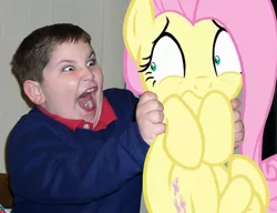 Size: 600x460 | Tagged: safe, artist:dtkraus, derpibooru import, fluttershy, human, pony, child, creepy, holding a pony, irl, irl human, photo, ponies in real life, red eye, scared, target demographic, terror, wat