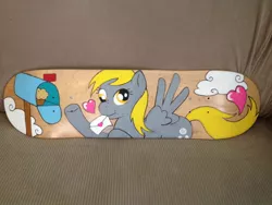 Size: 1024x768 | Tagged: safe, artist:matteglaze, derpibooru import, derpy hooves, pegasus, pony, custom, female, heart, mare, mouth hold, muffin, scrunchy face, skateboard