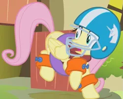 Size: 523x423 | Tagged: safe, derpibooru import, screencap, fluttershy, pegasus, pony, dragonshy, american football, cropped, female, floatie, folded wings, football helmet, helmet, inner tube, mare, outfit catalog, solo, startled, wings