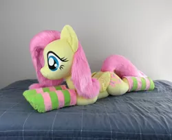 Size: 2453x2000 | Tagged: safe, artist:qtpony, derpibooru import, fluttershy, pony, adorable face, bed, bedroom, clothes, cute, fluffy, irl, life size, lying down, photo, plushie, show accurate, shyabetes, socks, solo, striped socks