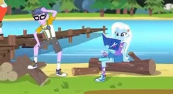 Size: 446x244 | Tagged: safe, derpibooru import, screencap, microchips, trixie, equestria girls, legend of everfree, background human, camp everfree outfits, clothes, converse, glasses, logs, pier, reading, shoes, shorts, sitting, sneakers, socks