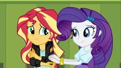 Size: 1100x618 | Tagged: safe, derpibooru import, screencap, rarity, sunset shimmer, equestria girls, friendship games, bracelet, clothes, comforting, duo, female, hairpin, hands on arms, jacket, jewelry, leather jacket, lockers, smiling