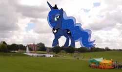 Size: 1024x606 | Tagged: safe, artist:theotterpony, derpibooru import, princess luna, alicorn, human, pony, bouncy castle, female, fountain, giant pony, irl, irl human, lidded eyes, macro, mare, mega luna, park, photo, ponies in real life, smiling
