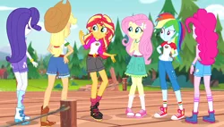 Size: 996x566 | Tagged: safe, derpibooru import, screencap, applejack, fluttershy, pinkie pie, rainbow dash, rarity, sunset shimmer, equestria girls, legend of everfree, balloon, boots, camp everfree outfits, clothes, converse, cowboy boots, embrace the magic, hand on hip, humane five, jeans, pants, pier, raised leg, rear view, shoes, shorts, sneakers, socks, sun, tree, wristband