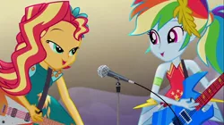 Size: 1100x618 | Tagged: safe, derpibooru import, screencap, rainbow dash, sunset shimmer, equestria girls, legend of everfree, crystal gala, electric guitar, flying v, guitar, legend you were meant to be, lidded eyes, looking at each other, microphone, sunset shredder