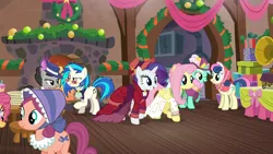 Size: 1920x1080 | Tagged: safe, derpibooru import, screencap, bon bon, bonnie rose, flutterholly, fluttershy, lyra heartstrings, merry, octavia melody, rarity, sweetie drops, vinyl scratch, earth pony, pegasus, pony, unicorn, a hearth's warming tail, bonnet, christmas wreath, clothes, dress, female, fire, hat, mare, table, victrola scratch, wreath