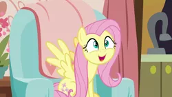 Size: 1280x720 | Tagged: safe, derpibooru import, screencap, fluttershy, pegasus, pony, discordant harmony, couch, cute, female, mare, open mouth, shyabetes, sitting, smiling, solo, spread wings, weapons-grade cute, wings