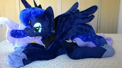 Size: 1600x900 | Tagged: safe, artist:masha05, derpibooru import, princess luna, alicorn, pony, female, irl, jewelry, lidded eyes, mare, photo, plushie, prone, regalia, solo, spread wings, wings