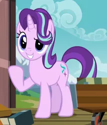 Size: 666x774 | Tagged: safe, derpibooru import, screencap, starlight glimmer, pony, unicorn, uncommon bond, blue eyes, book, cart, cloud, cropped, cute, cutie mark, female, glimmerbetes, grin, hair over one eye, horn, mare, mountain, raised eyebrow, raised hoof, smiling, solo, train station, wheel