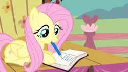 Size: 1280x720 | Tagged: safe, derpibooru import, screencap, fluttershy, pegasus, pony, filli vanilli, book, cute, female, fence, mare, mouth hold, pencil, shyabetes, solo, writing