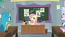 Size: 1280x720 | Tagged: safe, derpibooru import, screencap, fluttershy, gallus, silverstream, classical hippogriff, gryphon, hippogriff, pegasus, pony, school daze, animal, apple, classroom, desk, drawing, female, food, male, mare, pointer, teacher, teaching
