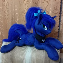 Size: 960x960 | Tagged: safe, artist:burgunzik, derpibooru import, princess luna, alicorn, pony, :t, alternate hairstyle, bedroom eyes, bow, female, hair bow, irl, looking at you, mare, missing accessory, photo, plushie, ponytail, prone, smiling, solo