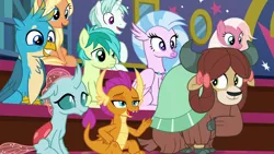 Size: 1280x720 | Tagged: safe, derpibooru import, screencap, gallus, ocellus, sandbar, silverstream, smolder, yona, changedling, changeling, classical hippogriff, dragon, earth pony, gryphon, hippogriff, pony, unicorn, yak, a rockhoof and a hard place, beak, blanket, bow, chest fluff, claws, cloven hooves, dragoness, fangs, female, floppy ears, hair bow, hair ribbon, horn, jewelry, male, mare, monkey swings, necklace, open mouth, raised hoof, smiling, stallion, student six, teenager, wings