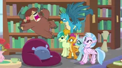 Size: 1280x720 | Tagged: safe, derpibooru import, screencap, gallus, ocellus, sandbar, silverstream, smolder, yona, changedling, changeling, classical hippogriff, dragon, earth pony, gryphon, hippogriff, pony, yak, what lies beneath, beanbag chair, book, bookshelf, bow, cloven hooves, dragoness, female, hair bow, jewelry, library, male, monkey swings, necklace, student six, teenager
