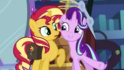 Size: 1920x1080 | Tagged: safe, derpibooru import, screencap, starlight glimmer, sunset shimmer, pony, unicorn, equestria girls, mirror magic, spoiler:eqg specials, bag, confused, cute, duo, excited, eye contact, female, glimmerbetes, grin, happy, library, looking at each other, mare, mirror, open mouth, raised hoof, saddle bag, smiling, twilight's castle, underhoof