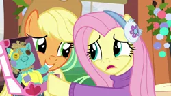 Size: 1280x720 | Tagged: safe, derpibooru import, screencap, applejack, fluttershy, holly the hearths warmer doll, pony, best gift ever, clothes, earmuffs, friendship express, pushing, sweater, sweatershy