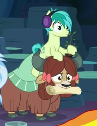 Size: 589x765 | Tagged: safe, derpibooru import, screencap, sandbar, silverstream, yona, earth pony, pony, yak, uprooted, bow, cloven hooves, cropped, cute, duo focus, earmuffs, female, frown, hair bow, hoof hold, male, monkey swings, mouth hold, ponies riding yaks, pony hat, riding, sapling, scroll, wide eyes, yonadorable