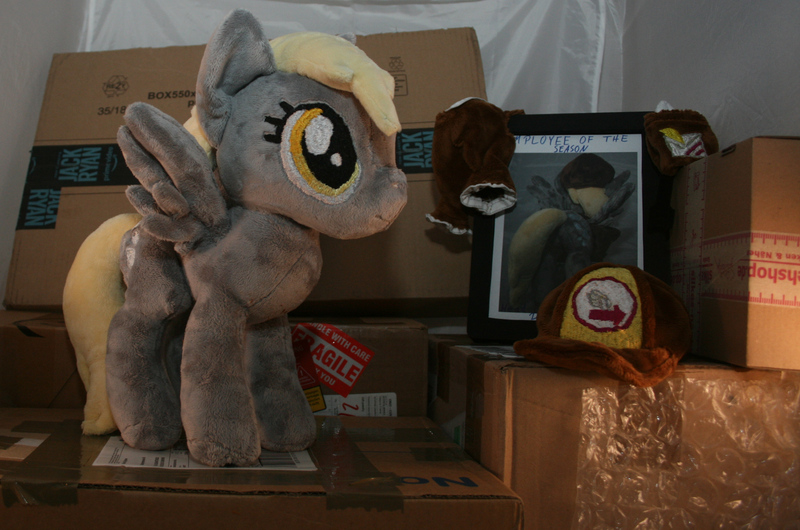 Size: 3100x2052 | Tagged: safe, artist:bastler, derpibooru import, derpy hooves, pegasus, pony, bubble butt, butt, cap, clothes, employee of the month, female, hat, irl, mail, mailbag, mailmare, mare, package, photo, picture frame, plushie, solo, uniform