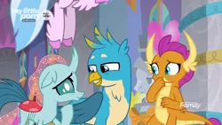 Size: 1280x720 | Tagged: safe, derpibooru import, screencap, gallus, ocellus, silverstream, smolder, changedling, changeling, dragon, gryphon, she's all yak, amused, claws, curved horn, dragoness, female, folded wings, grin, hand over mouth, hooves, horn, horns, looking at each other, male, raised hoof, slit eyes, smiling, squint, stifling laughter, teenaged dragon, teenager, trio, unshorn fetlocks, wings