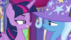 Size: 1136x640 | Tagged: safe, derpibooru import, screencap, trixie, twilight sparkle, twilight sparkle (alicorn), alicorn, pony, unicorn, no second prances, cape, clothes, duo, fake smile, female, folded wings, forced smile, grin, hat, lidded eyes, long time no see, mare, narrowed eyes, rivalry, smiling, suspicious, trixie's cape, trixie's hat, twilight's castle, wings