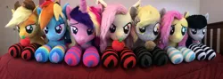 Size: 4680x1658 | Tagged: safe, artist:qtpony, derpibooru import, applejack, derpy hooves, fluttershy, octavia melody, princess cadance, rainbow dash, bat pony, pony, apple, bat ponified, bedroom eyes, clothes, flutterbat, food, irl, muffin, photo, plushie, prone, race swap, socks, striped socks