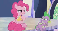 Size: 1600x864 | Tagged: safe, derpibooru import, screencap, pinkie pie, spike, dragon, pony, the last laugh, cupcake, eating, food, munching, plastic, silly, silly pony, sitting, table, twilight's castle, weirded out, winged spike