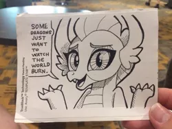 Size: 640x480 | Tagged: artist:docwario, dark comedy, derpibooru import, dialogue, dragon, dragoness, female, monochrome, photo, safe, shrug, smolder, solo, sticker, traditional art