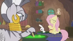 Size: 1600x900 | Tagged: safe, derpibooru import, screencap, angel bunny, fluttershy, zecora, pegasus, pony, rabbit, zebra, she talks to angel, angry, animal, brew, candle, cauldron, container, door, ear piercing, earring, female, frazzled, jewelry, male, mare, neck rings, piercing, shelf, sitting, trio, upset, window, zecora's hut