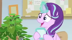 Size: 1600x900 | Tagged: safe, derpibooru import, screencap, phyllis, starlight glimmer, pony, unicorn, a horse shoe-in, bulletin board, female, grin, house plant, levitation, magic, mare, nervous, nervous grin, office, philodendron, picture frame, smiling, telekinesis