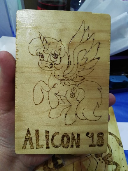 Size: 439x585 | Tagged: safe, artist:dawn-designs-art, artist:sapphire-burns-art, derpibooru import, oc, oc:spheres, alicorn, pony, convention mascots, convention:alicon, mascot, photo, pyrography, solo, traditional art