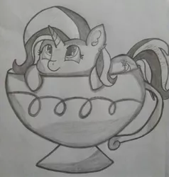 Size: 2448x2574 | Tagged: safe, artist:dashybestpony, derpibooru import, trixie, pony, unicorn, cup, cup of pony, cute, female, lying, mare, micro, monochrome, simple background, smiling, solo, teacup, that pony sure does love teacups, traditional art