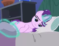 Size: 582x455 | Tagged: safe, derpibooru import, screencap, starlight glimmer, pony, unicorn, rock solid friendship, bed, blanket, cropped, female, glowing horn, horn, levitation, lidded eyes, lying down, magic, mare, pillow, solo, starlight is not amused, telekinesis, unamused