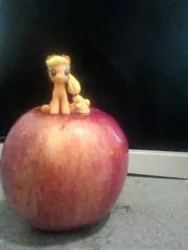 Size: 1200x1600 | Tagged: safe, derpibooru import, applejack, earth pony, pony, apple, food, giant apple, irl, photo, sitting, tiny, tiny ponies, toy