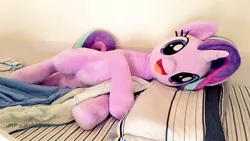 Size: 1024x576 | Tagged: safe, artist:nekokevin, derpibooru import, starlight glimmer, pony, unicorn, series:nekokevin's glimmy, :d, bed, bedsheets, cute, female, glimmerbetes, happy, irl, looking at you, lying down, mare, open mouth, photo, pillow, plushie, smiling, solo