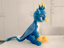 Size: 1024x768 | Tagged: safe, artist:nekokevin, derpibooru import, gallus, gryphon, folded wings, irl, lidded eyes, male, photo, plushie, side view, sitting, smiling, solo, teenager, wings