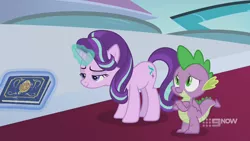 Size: 1280x720 | Tagged: safe, derpibooru import, screencap, spike, starlight glimmer, dragon, pony, unicorn, memories and more, spoiler:memories and more, spoiler:mlp friendship is forever, 9now, book, crossed arms, duo, levitation, magic, magic aura, mid-blink screencap, scrapbook, telekinesis, winged spike