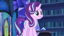 Size: 1920x1080 | Tagged: safe, derpibooru import, screencap, starlight glimmer, pony, unicorn, every little thing she does, book, bookshelf, door, female, frown, library, mare, solo, table, twilight's castle, twilight's castle library, worried