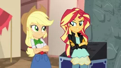 Size: 1280x718 | Tagged: safe, derpibooru import, screencap, applejack, sunset shimmer, equestria girls, movie magic, spoiler:eqg specials, >:d, clothes, cowboy hat, crossed arms, denim skirt, evil grin, freckles, grin, hat, jacket, leather jacket, looking at each other, pants, skirt, smiling, smirk, stetson