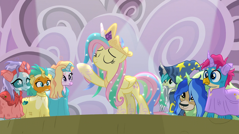 Size: 1920x1080 | Tagged: safe, derpibooru import, screencap, fluttershy, gallus, ocellus, sandbar, silverstream, smolder, yona, pegasus, pony, horse play, celestia costume, celestia's crown, clothes, cosplay, costume, crown, eyes closed, fake horn, female, jewelry, mare, play, raised hoof, regalia, shylestia, spotlight, star swirl the bearded costume, student six