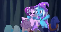 Size: 1024x537 | Tagged: safe, artist:raikoh, derpibooru import, hoo'far, princess flurry heart, starlight glimmer, trixie, pony, unicorn, road to friendship, audience, cape, clothes, crowd, female, hat, mare, open mouth, rearing, scene interpretation, smiling, stage, trixie's cape, trixie's hat, wrong eye color