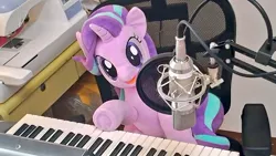 Size: 1024x577 | Tagged: safe, artist:nekokevin, derpibooru import, starlight glimmer, pony, unicorn, series:nekokevin's glimmy, chair, female, irl, keyboard, looking at you, mare, microphone, musical instrument, open mouth, photo, plushie, sewing machine, sitting, smiling, solo, underhoof