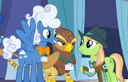 Size: 1042x665 | Tagged: safe, derpibooru import, screencap, fluffy clouds, galena, yuma spurs, big cat, gryphon, hybrid, pony, tiger, tiger griffon, princess spike (episode), appleloosa resident, background griffon, background pony, bowtie, clothes, cowboy hat, cropped, female, grand equestria pony summit, hat, jacket, male, mare, name tag, raised hoof, spread wings, stallion, trio, wings