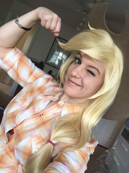 Size: 768x1024 | Tagged: applejack, applejack's hat, beautiful, blonde, clothes, cosplay, costume, cowboy hat, derpibooru import, hat, human, irl, irl human, one eye closed, photo, safe, smiling, wink