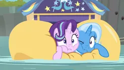 Size: 1920x1080 | Tagged: safe, derpibooru import, screencap, starlight glimmer, trixie, pony, unicorn, road to friendship, cheek squish, cheek to cheek, female, friendshipping, ghastly gorge, i guess we're stuck together, inflatable, inflatable raft, mare, one eye closed, prone, raft, river, squished, squishy cheeks, trixie's wagon, wagon, we're friendship bound